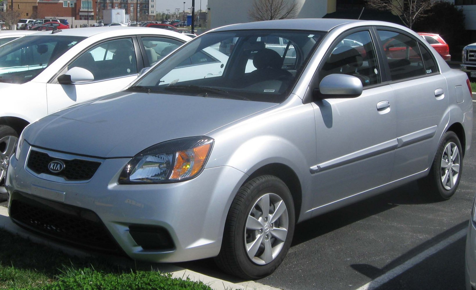 Front side view of a silver compact sedan with distinctive headlights and body lines.