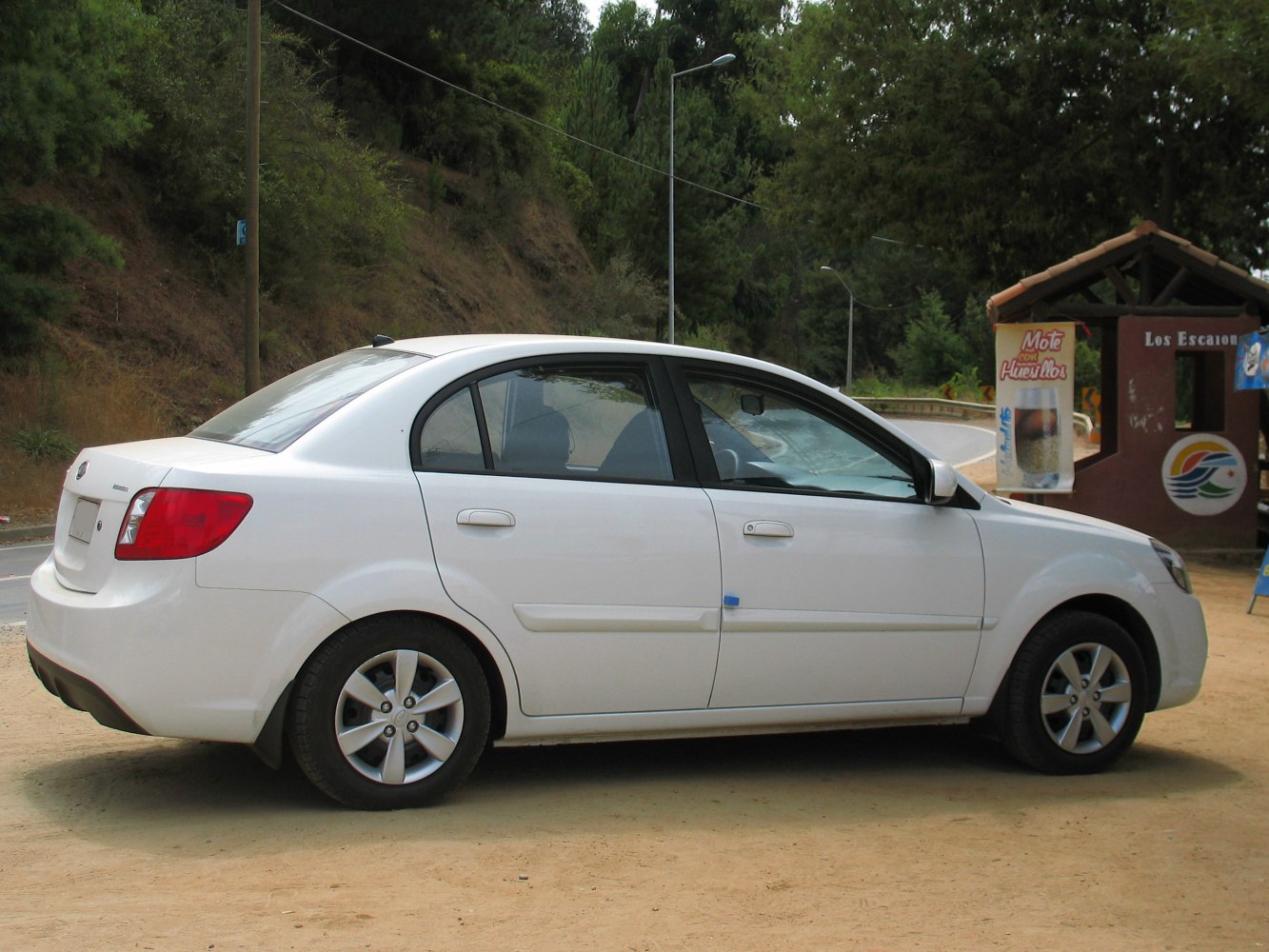 Side profile and rear view of a white sedan with four doors.