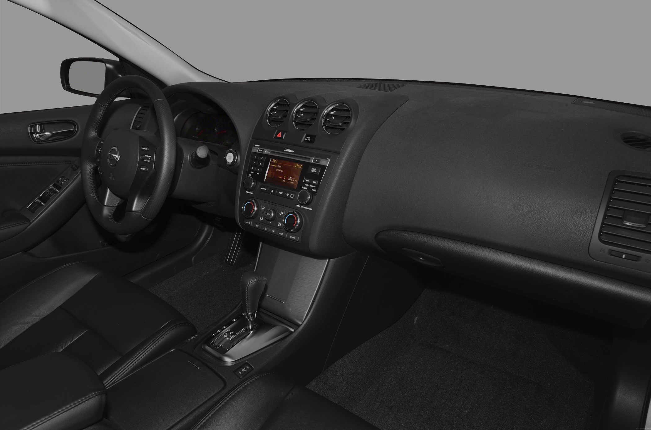 Car interior dashboard, steering wheel, and center console with controls