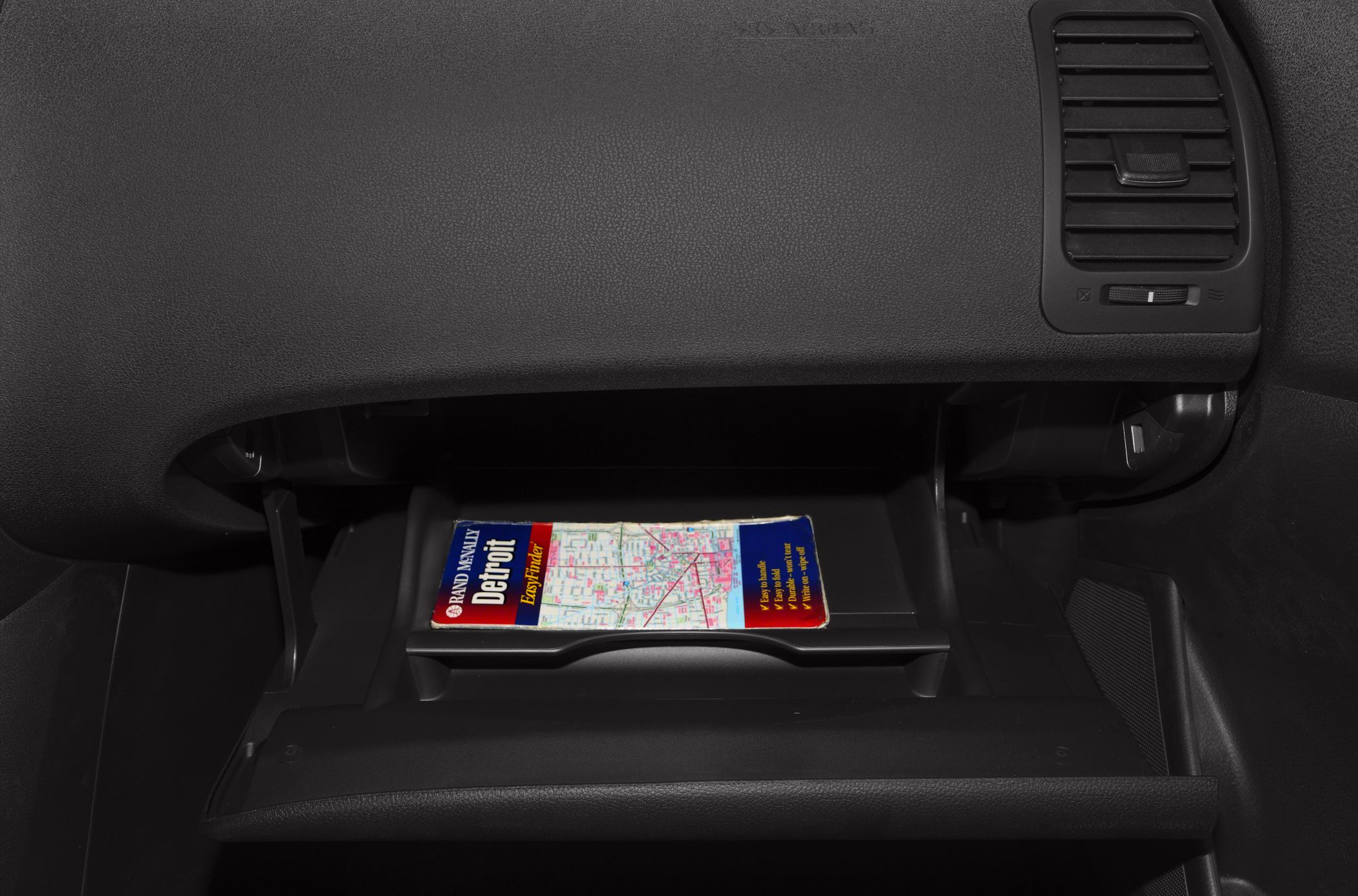 Open glovebox with map inside car dashboard