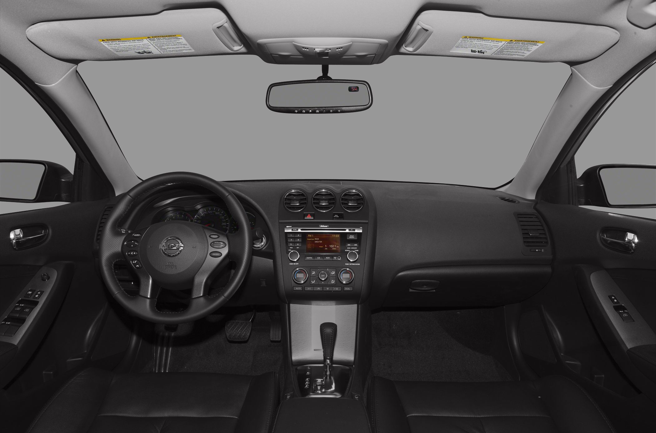 Steering wheel, dashboard, and center console of mid-2000s sedan interior
