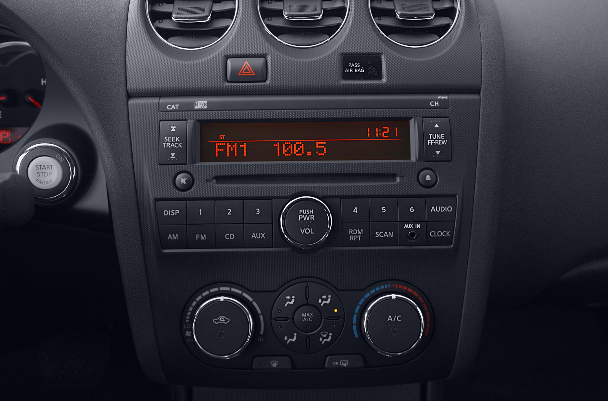 Close-up of car radio display tuned to FM and climate control dials