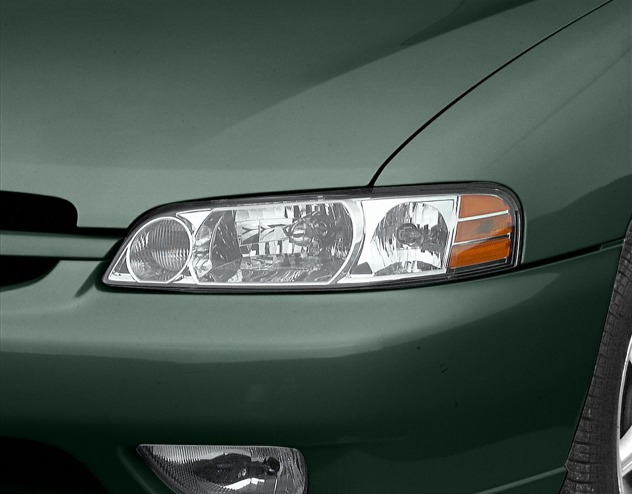 Close-up of front headlight and bumper with turn signal and fog light