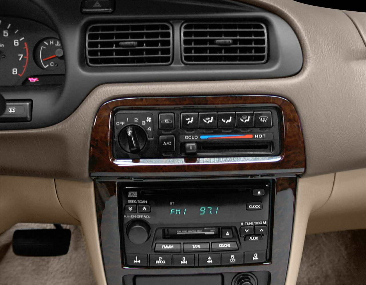 Vintage car dashboard with analog climate controls and audio system.