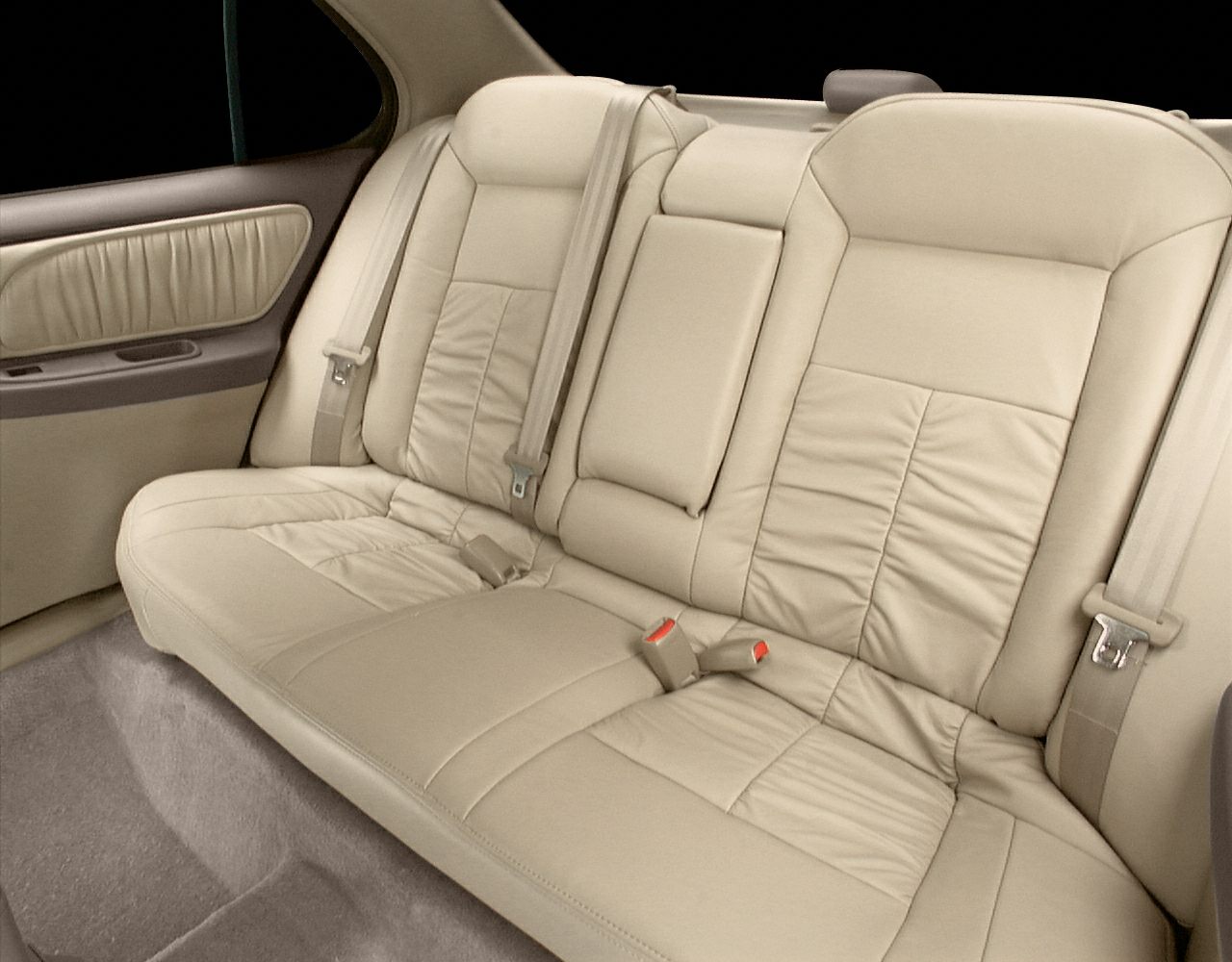 Beige leather rear seats with seatbelts and stitching details