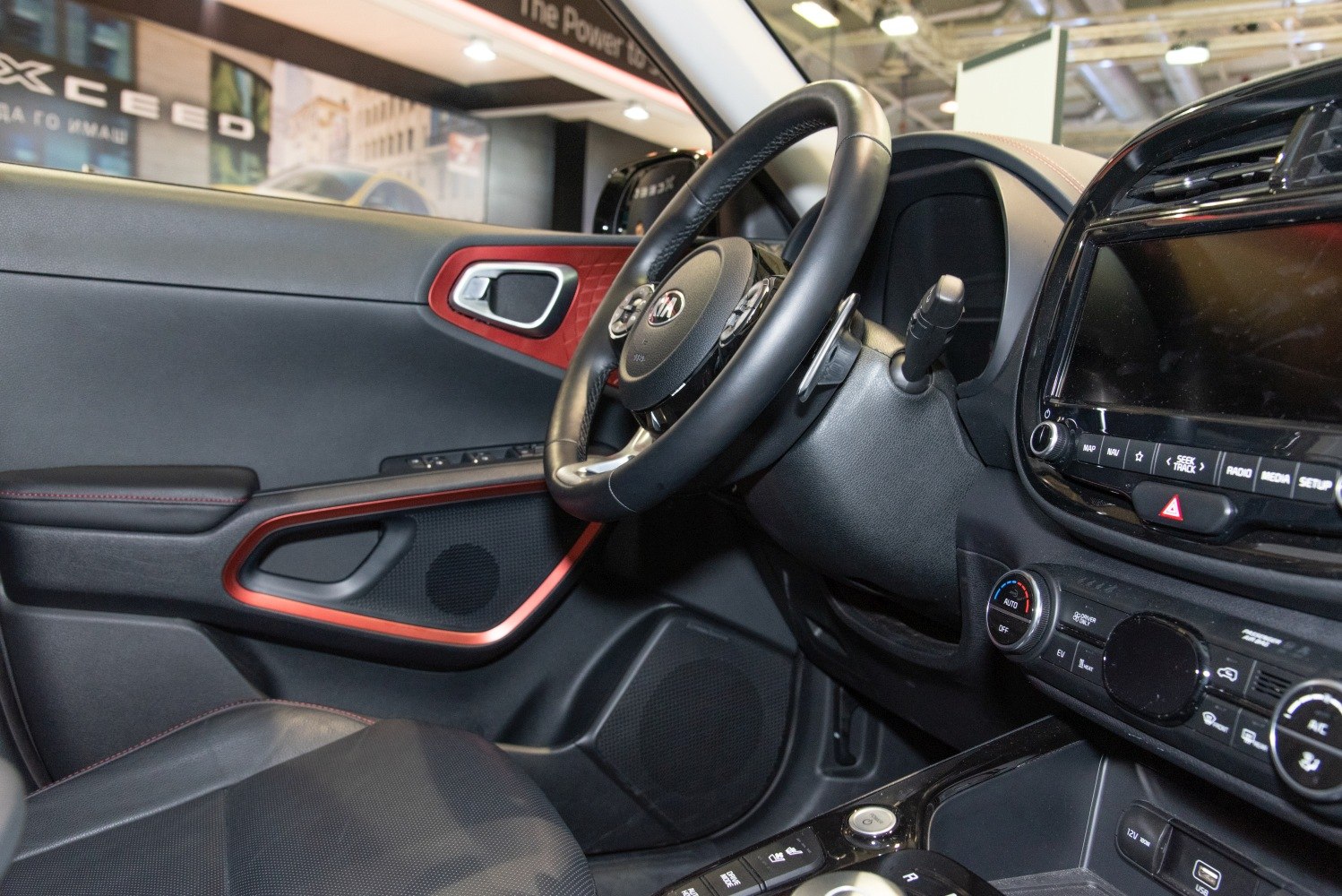 Steering wheel, dashboard controls, and door panel with red accents