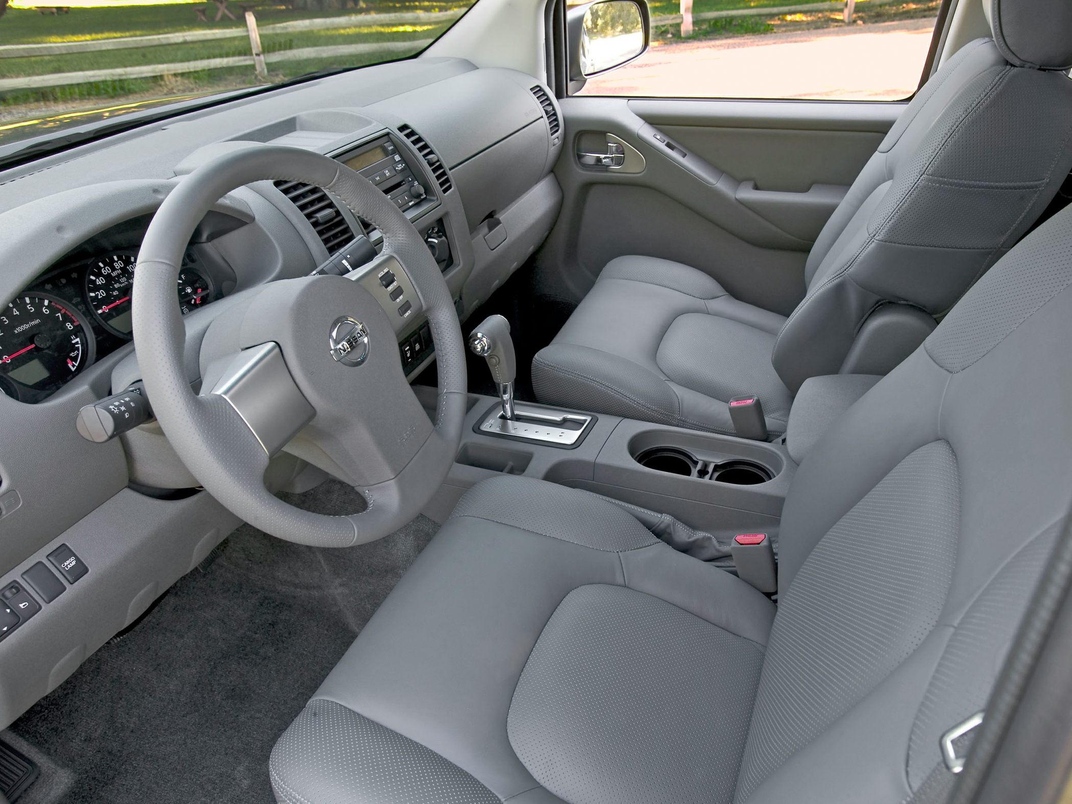 Modern vehicle interior with dashboard, steering wheel, and comfortable seats