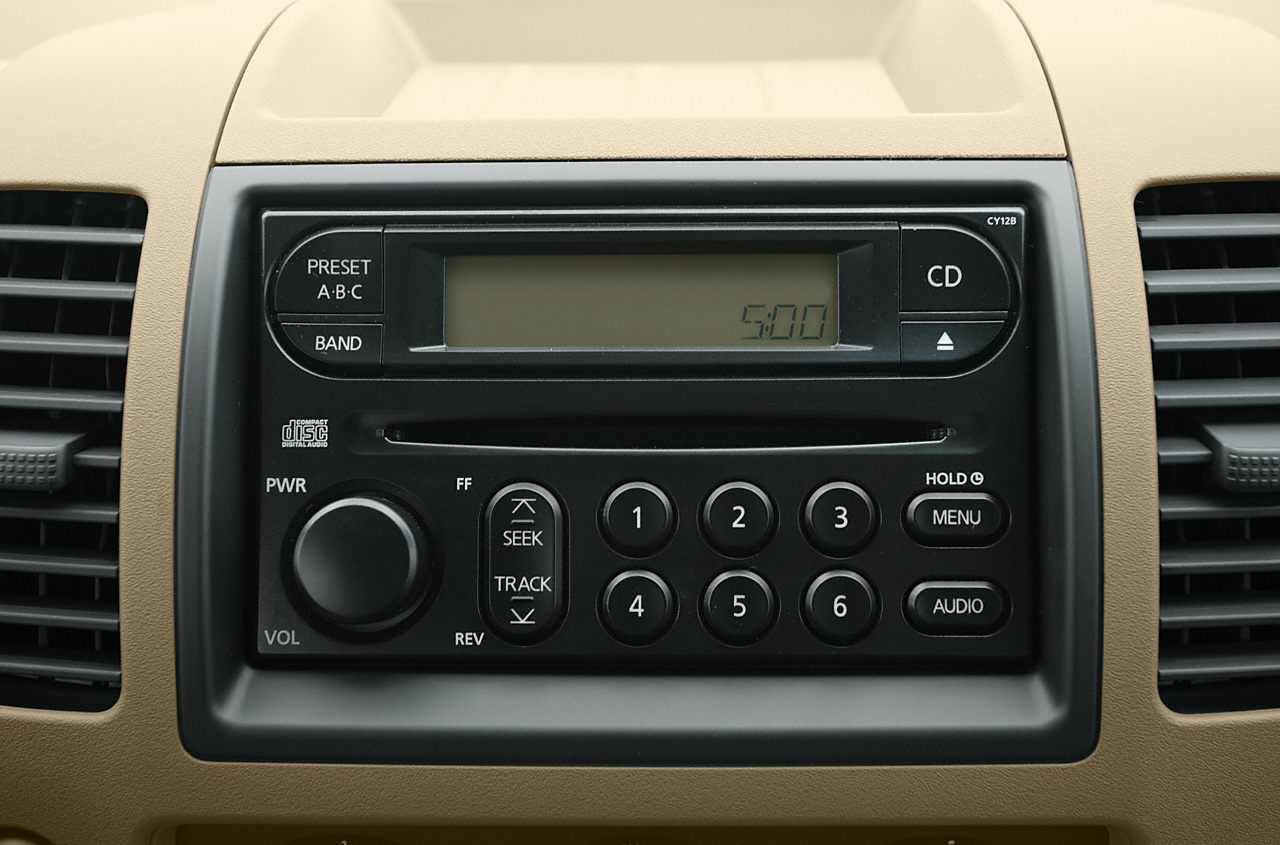 Radio and dashboard controls with CD player and buttons in vehicle interior.