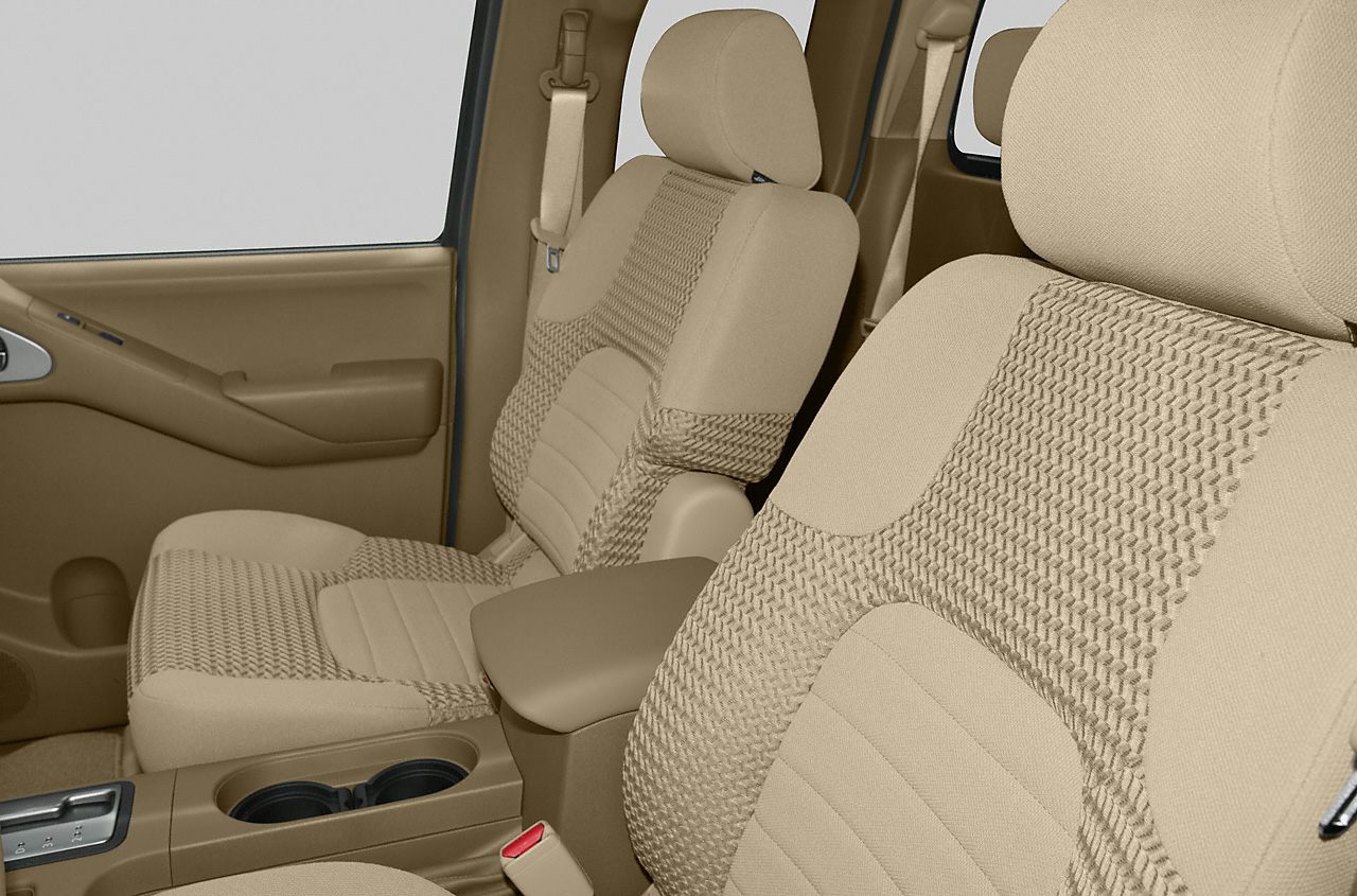 Beige fabric seats with patterned upholstery and center armrest cup holders.