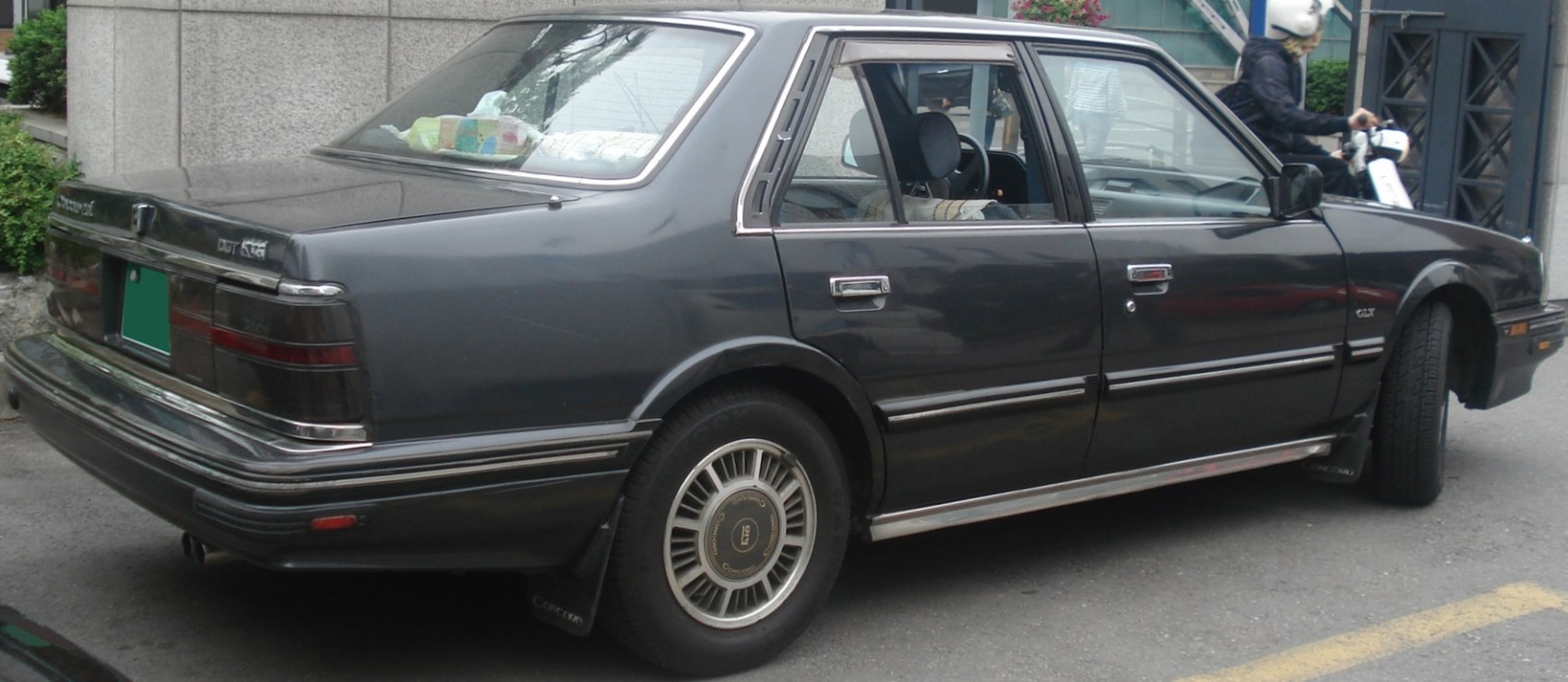 Rear side view of a 1980s sedan with chrome trims and classic wheels