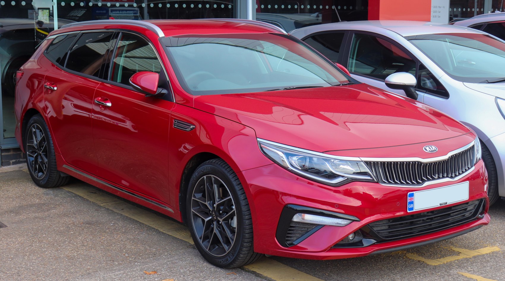 Red station wagon with sleek headlights and sporty alloy wheels