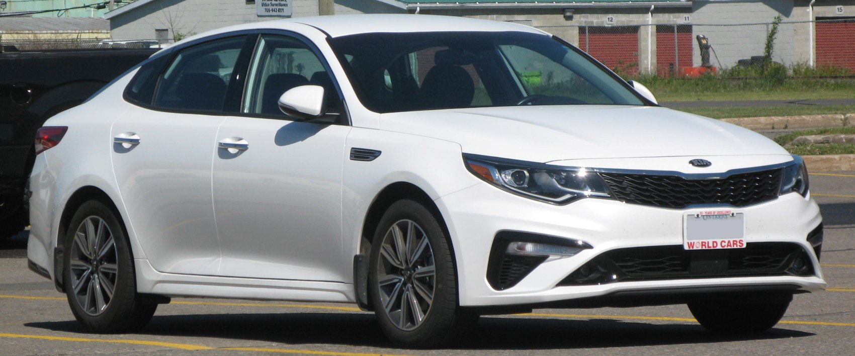 Front grille and sporty side profile of a white sedan