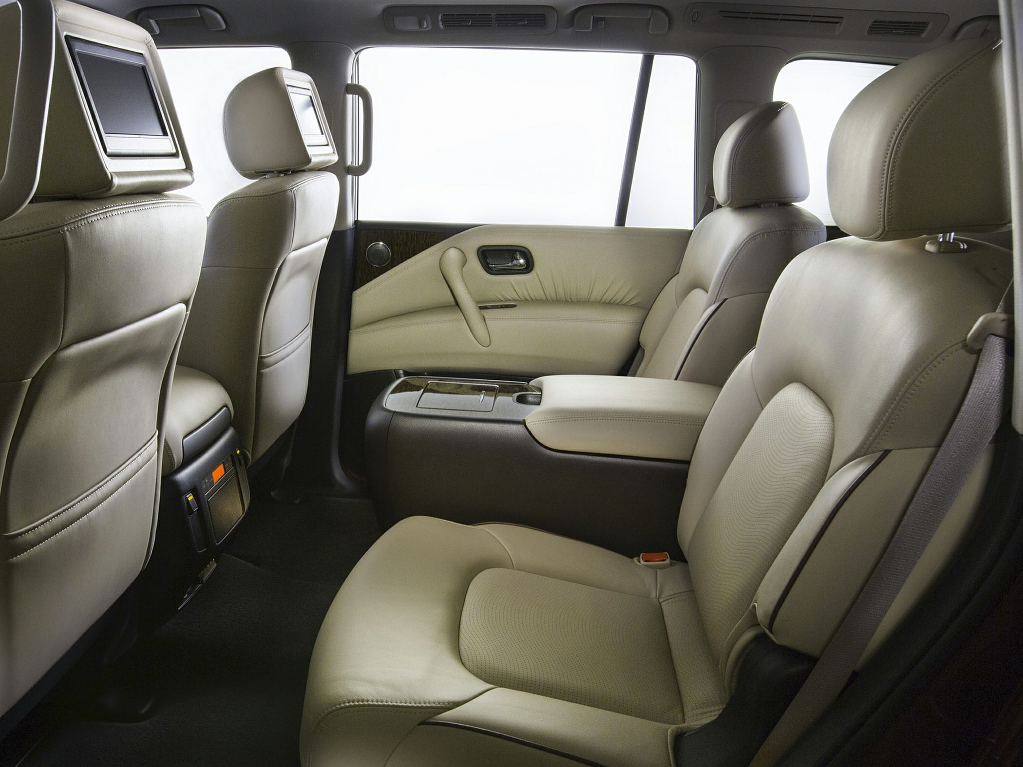 Spacious rear leather seats with entertainment screens and center armrest.