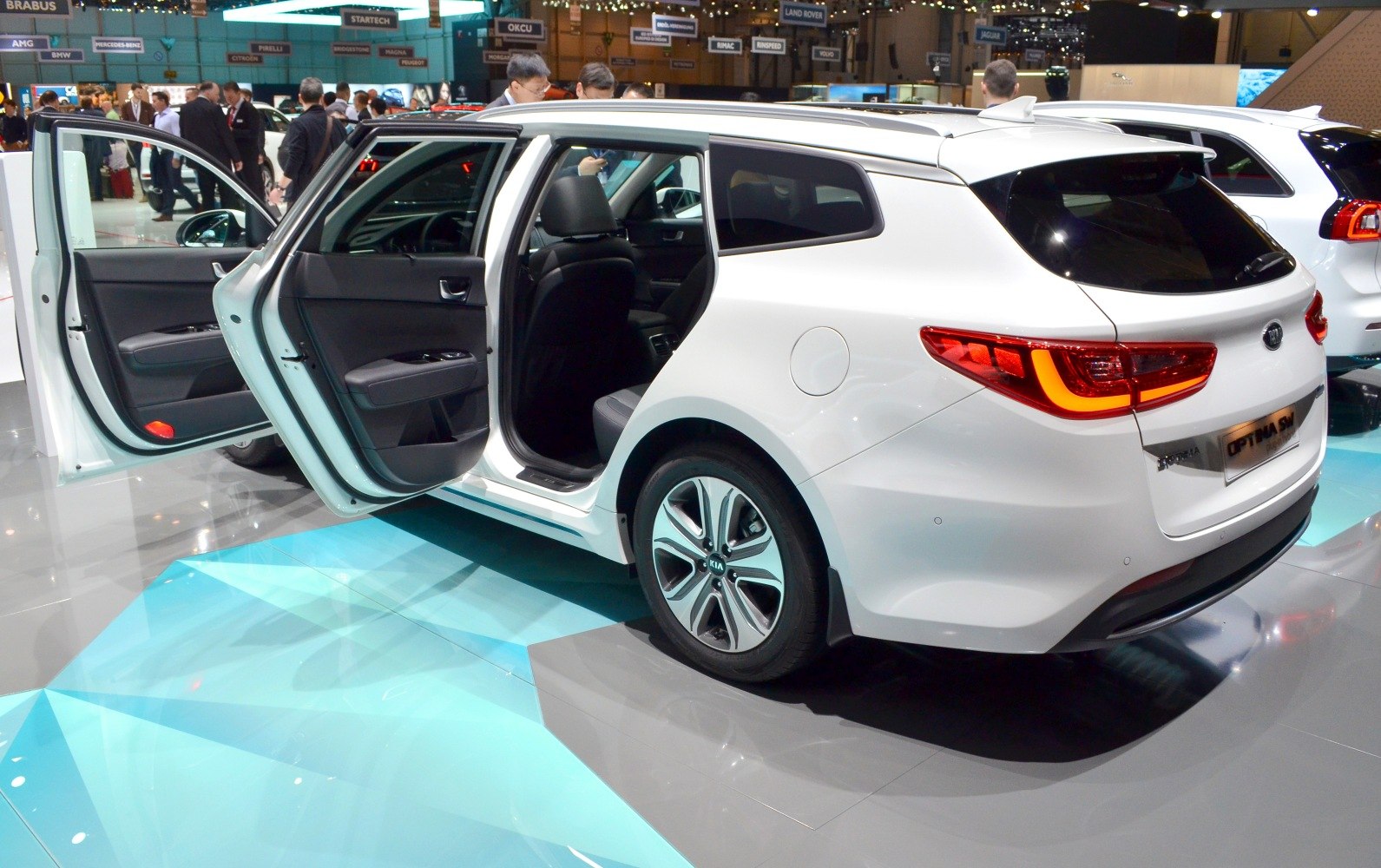 White estate car rear view with open front and rear doors and distinctive taillights.