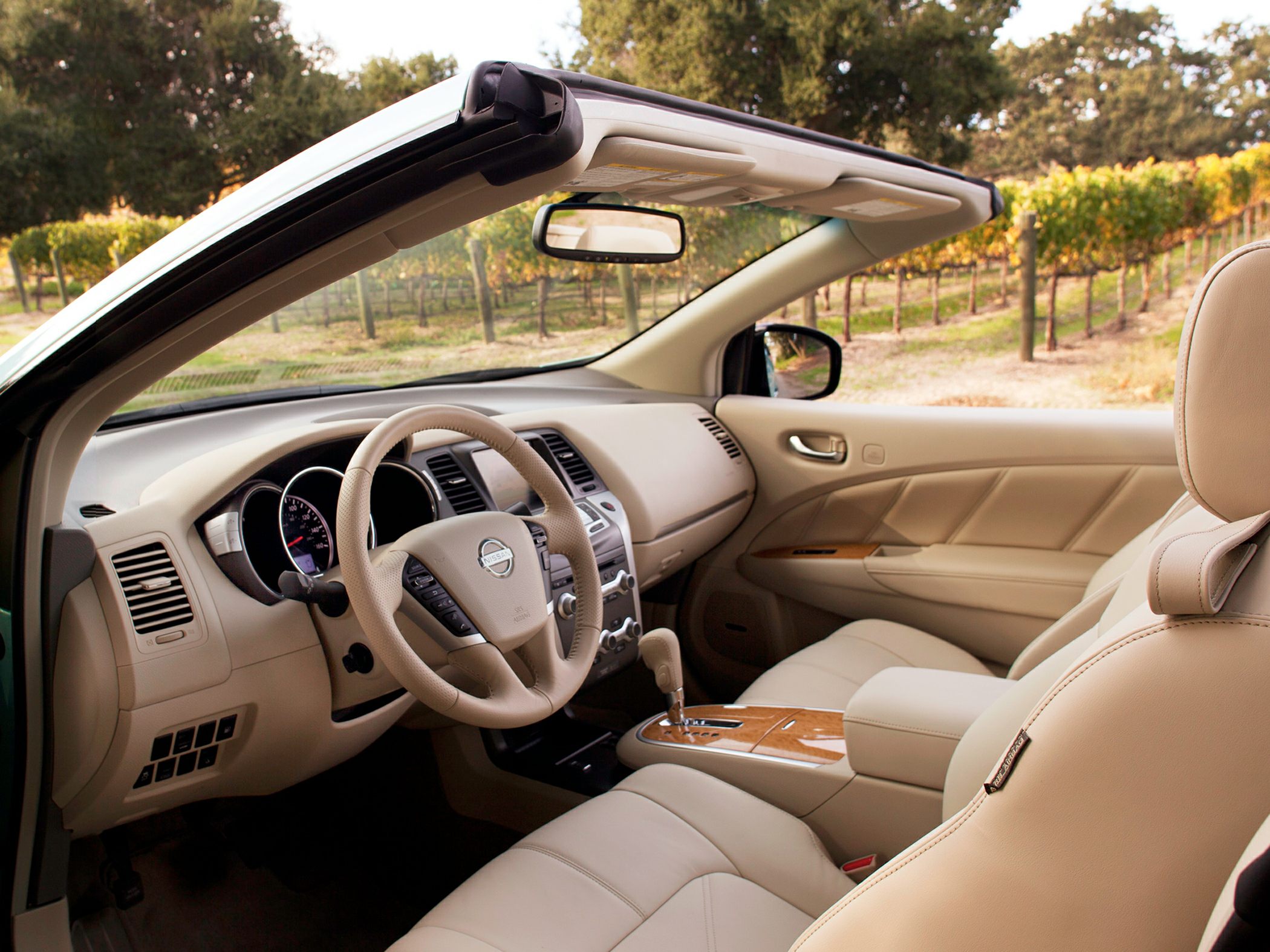 Beige leather convertible interior with wood trim and automatic gear shift