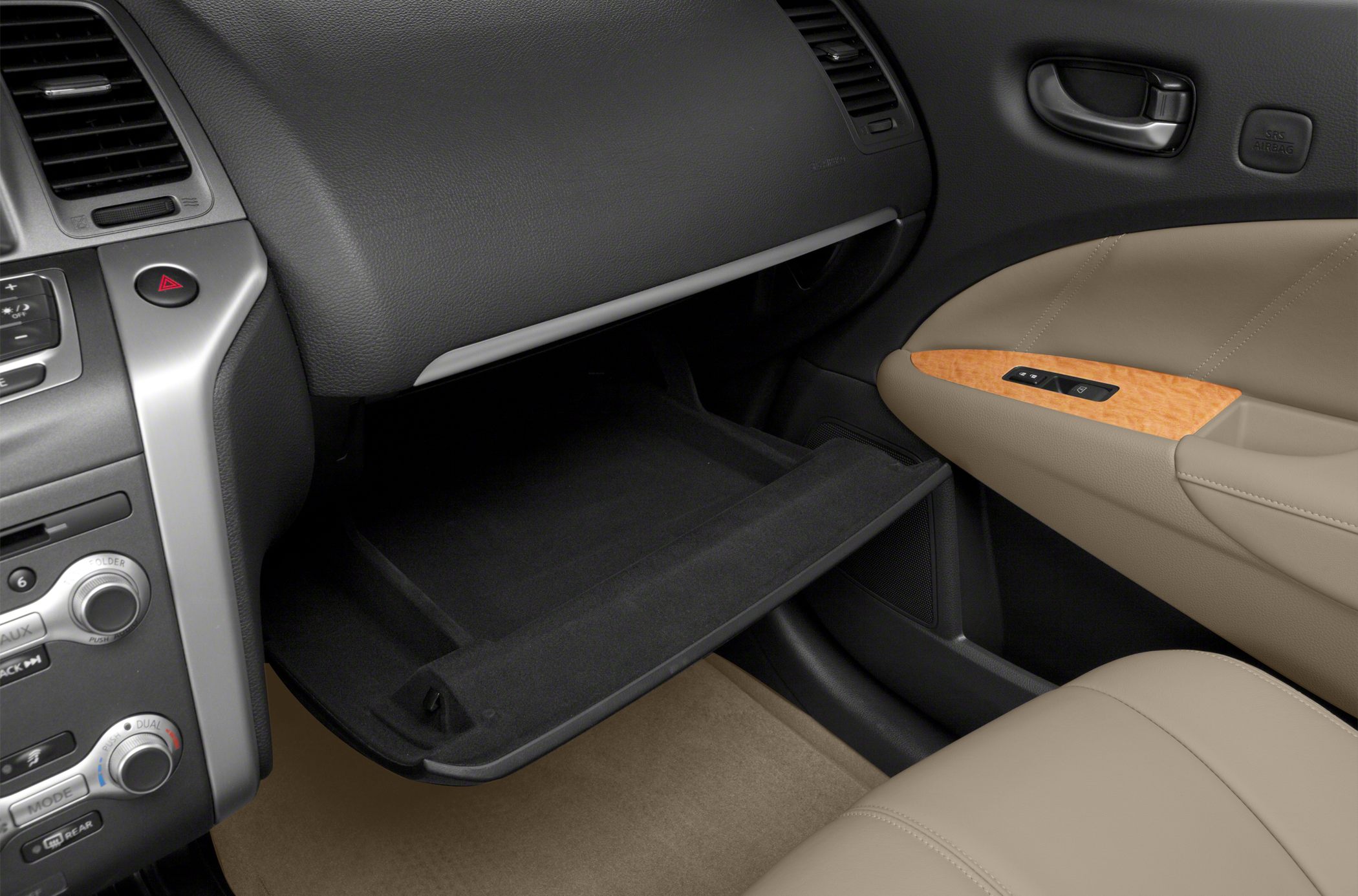 Open glove compartment and dashboard features in beige car interior