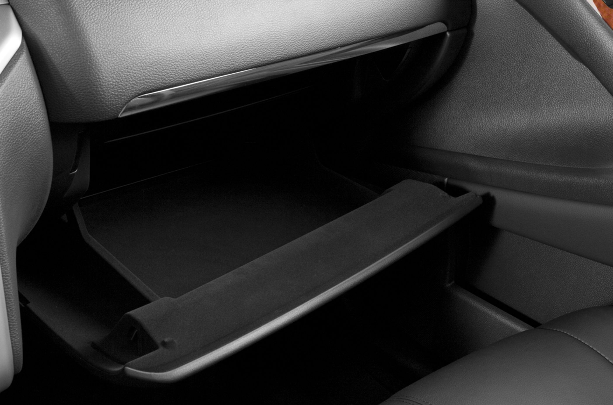 Open glove compartment inside car interior with dashboard and seat visible