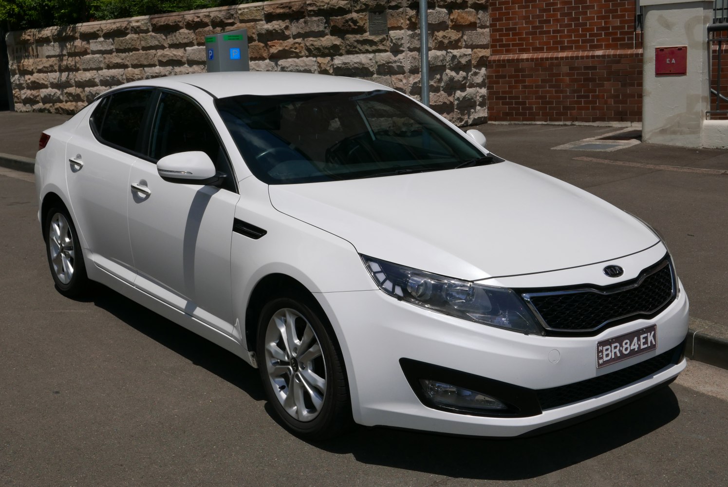 White mid-size sedan front three-quarter with alloy wheels and aerodynamic shape