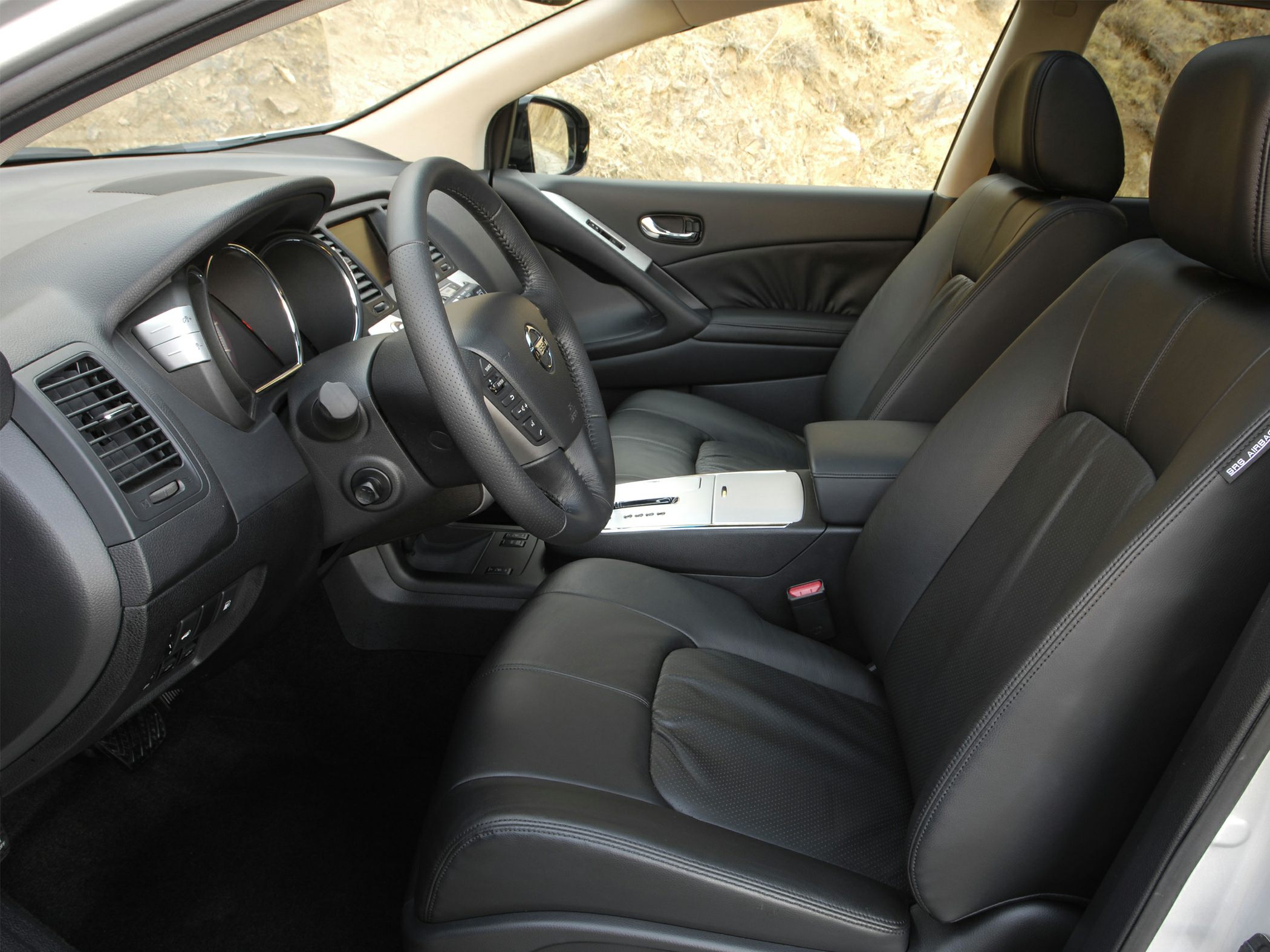 Black leather driver and front passenger seats with dashboard and steering wheel