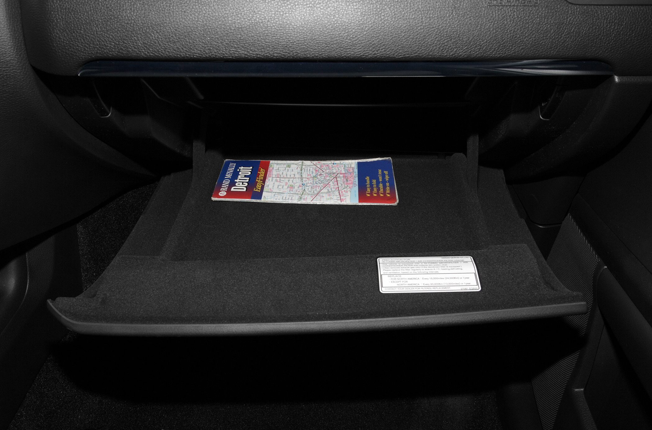 Open glove compartment with a map inside vehicle interior