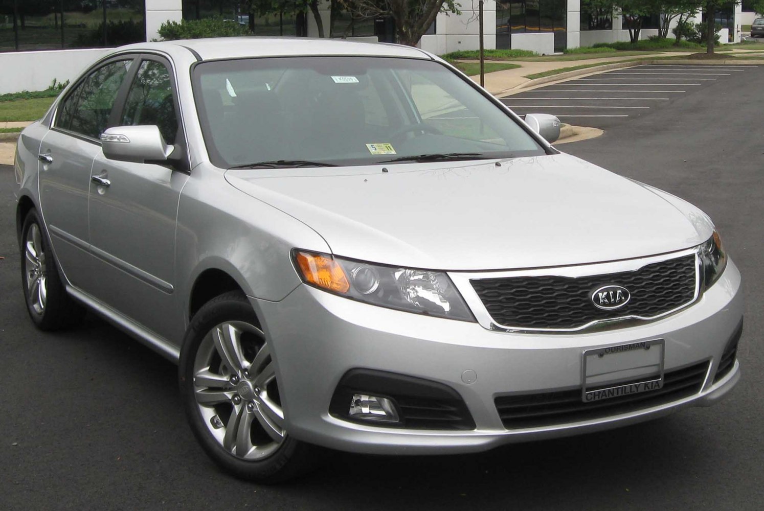 Silver sedan front angled view with headlights and grille.