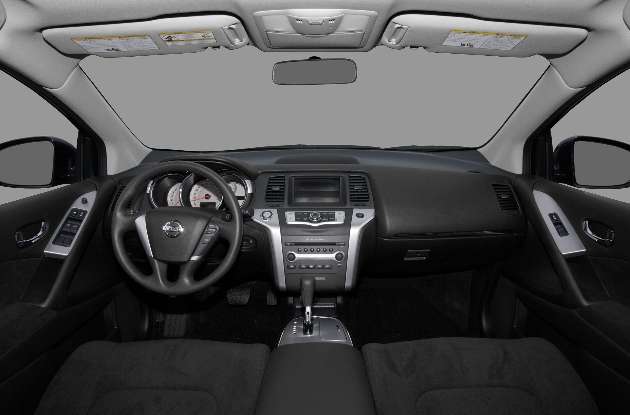 Dashboard and steering wheel interior of a vehicle with center console controls.