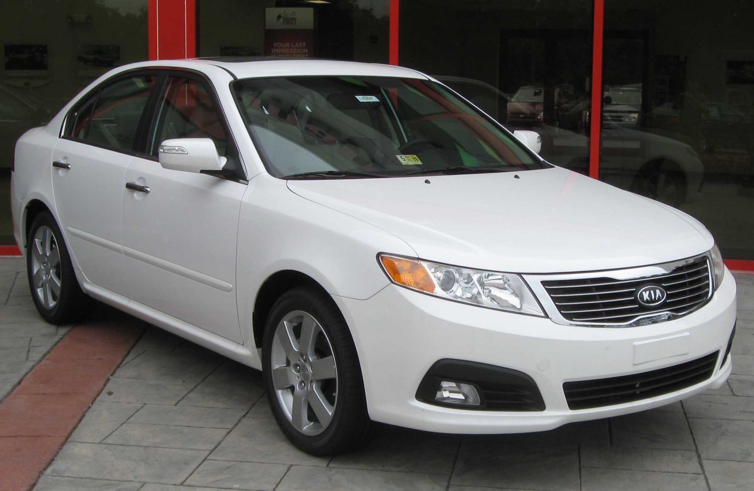 White sedan with modern grille and headlight design, front-side angle