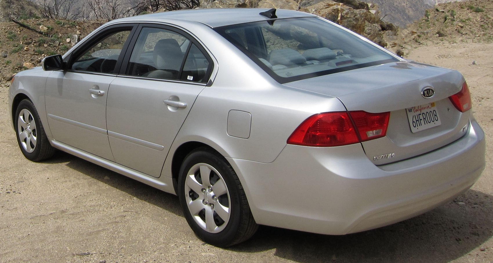 Rear side view of silver sedan with taillights and alloy wheels