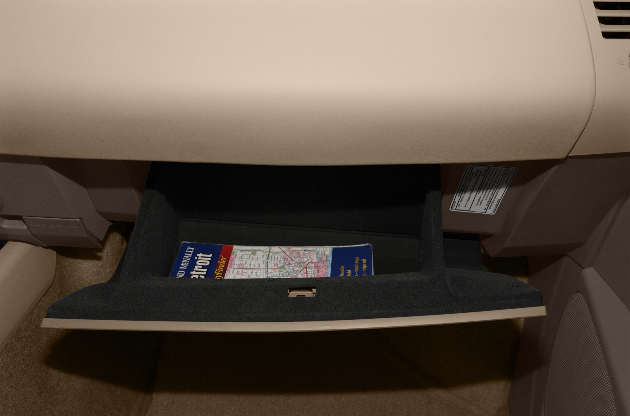 Open glove compartment with a map inside the vehicle's interior