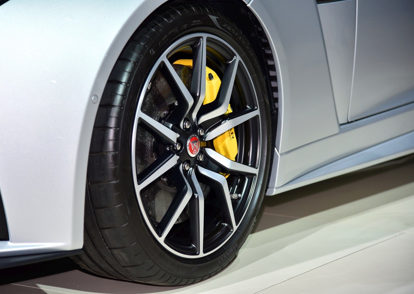 Alloy wheel with yellow brake caliper on silver car