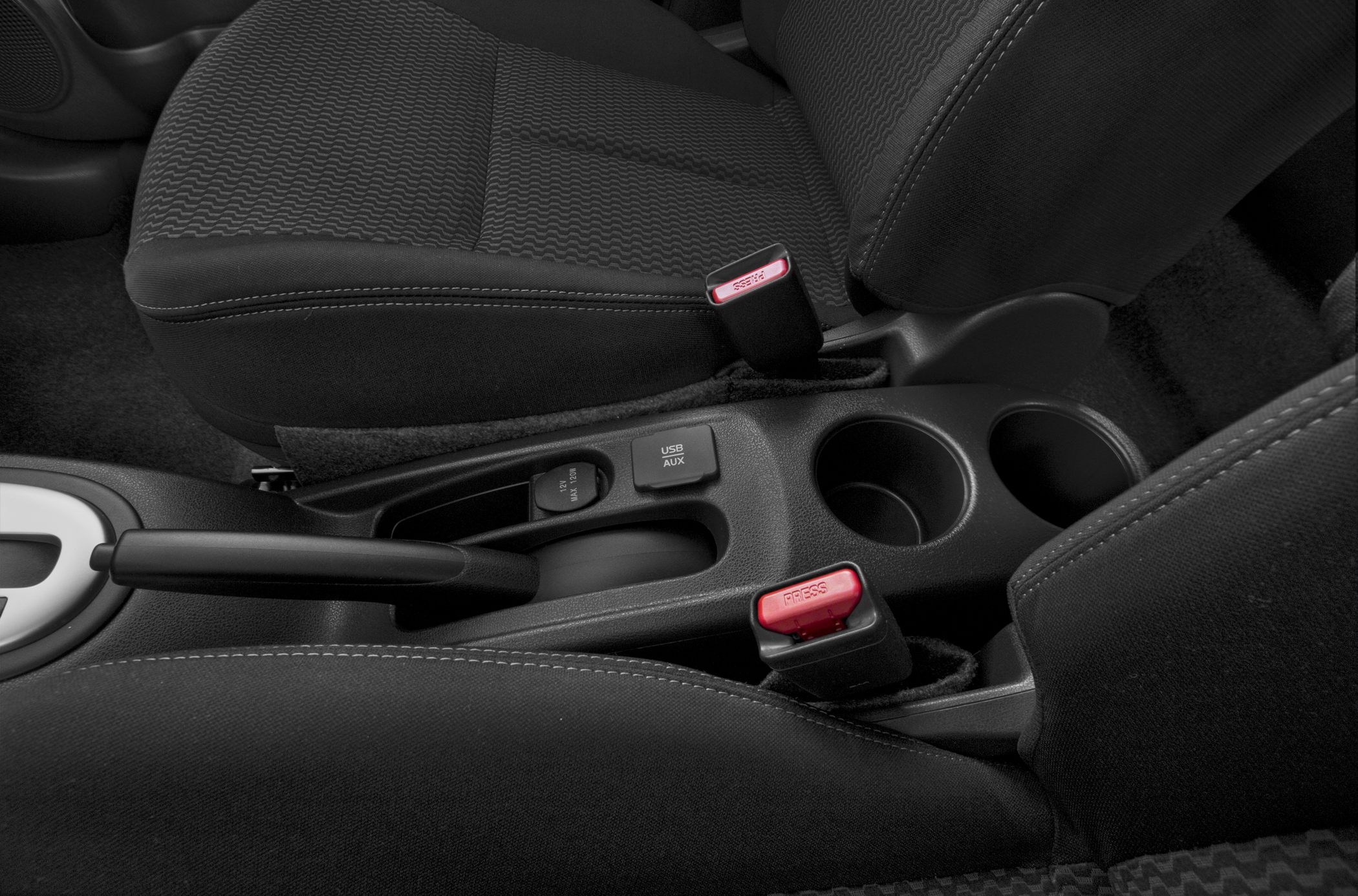 Center console with USB AUX ports, handbrake, cup holders, and fabric seats