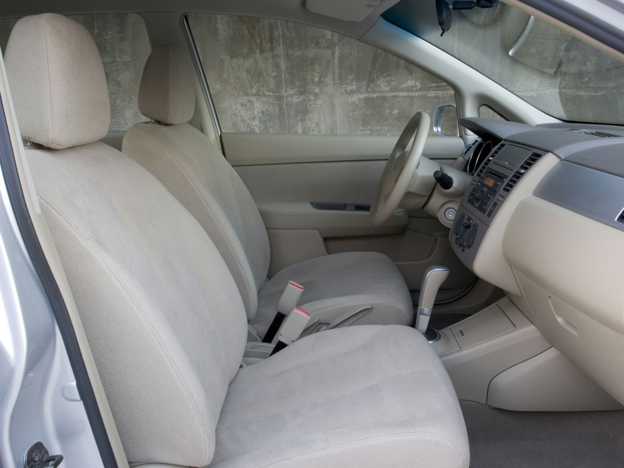Beige fabric seats and dashboard layout of a compact hatchback interior.