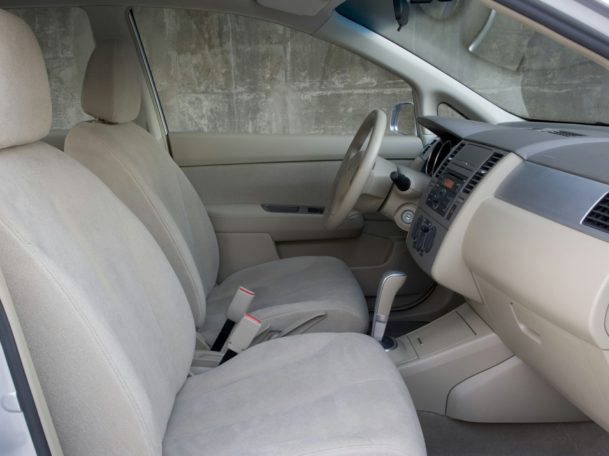 Beige fabric front seats and dashboard of a compact sedan interior