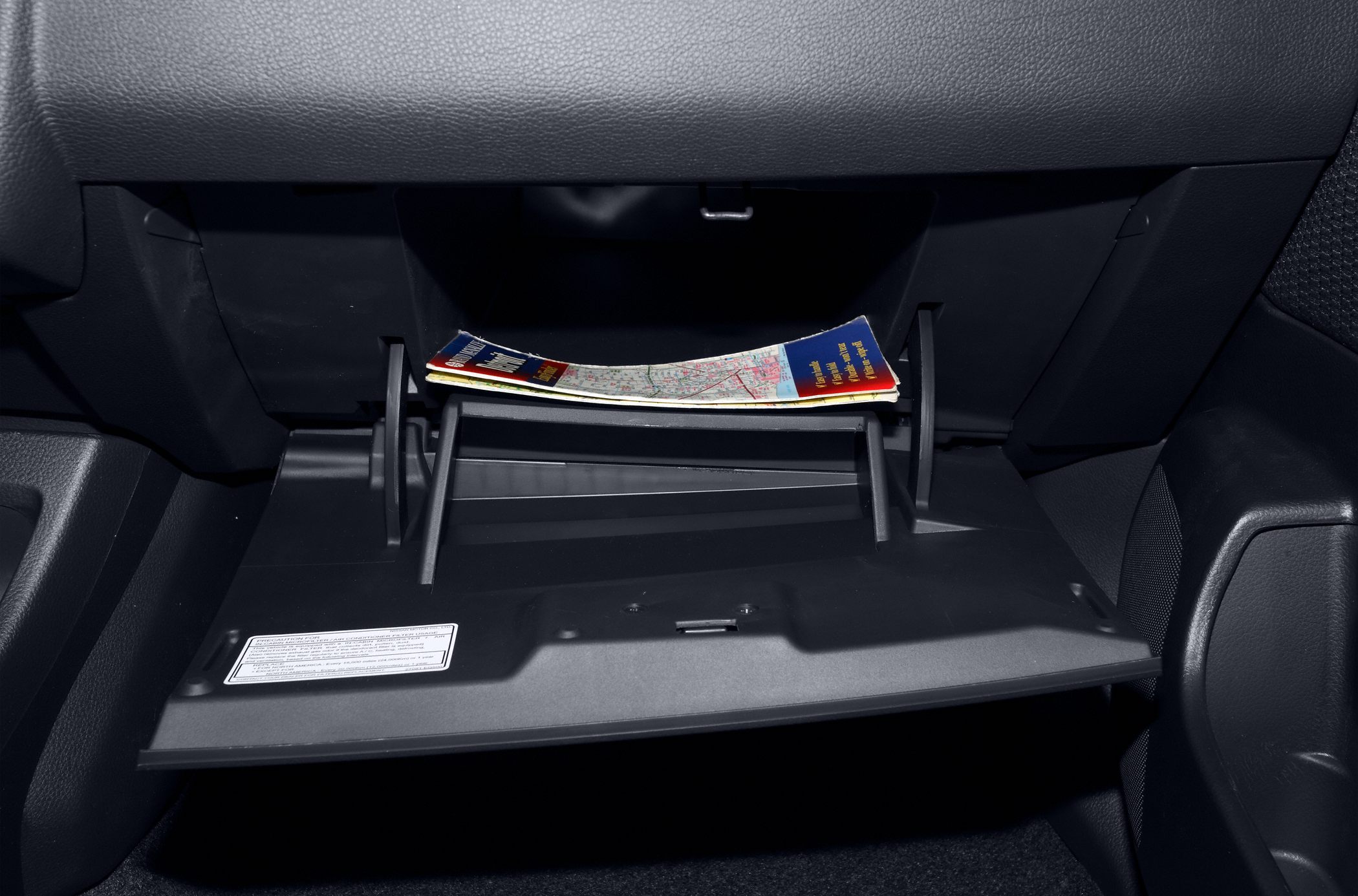 Glove box compartment with a folded map inside a car interior