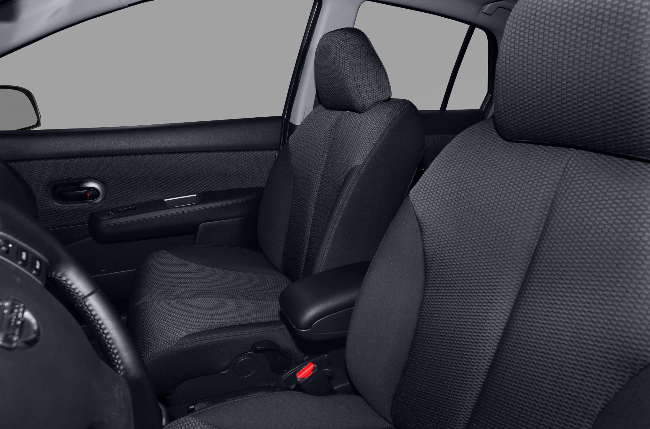 Front fabric seats and door interior panel with armrest and seatbelt buckle.