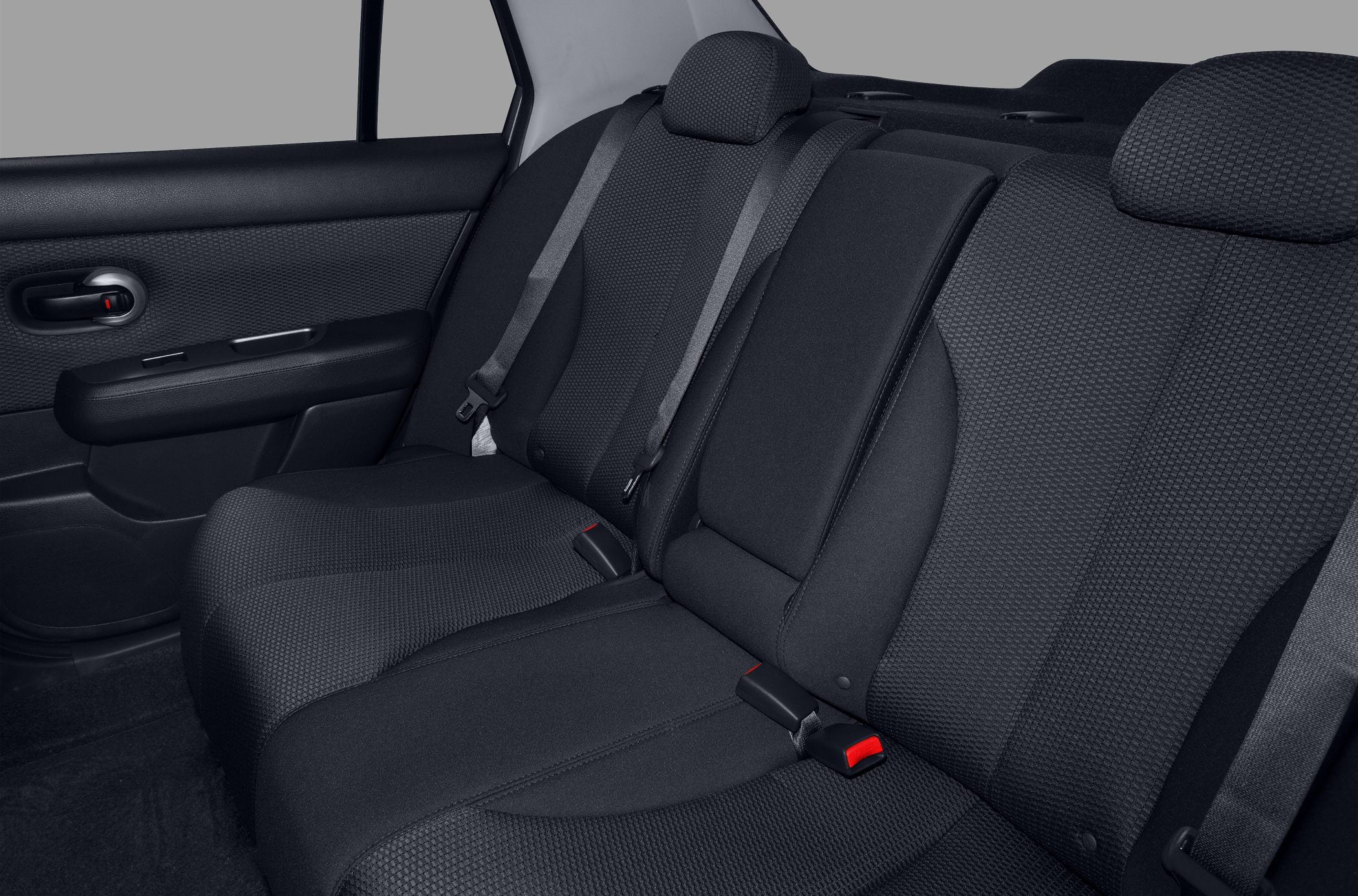 Rear seat fabric upholstery and seat belts in a compact sedan.