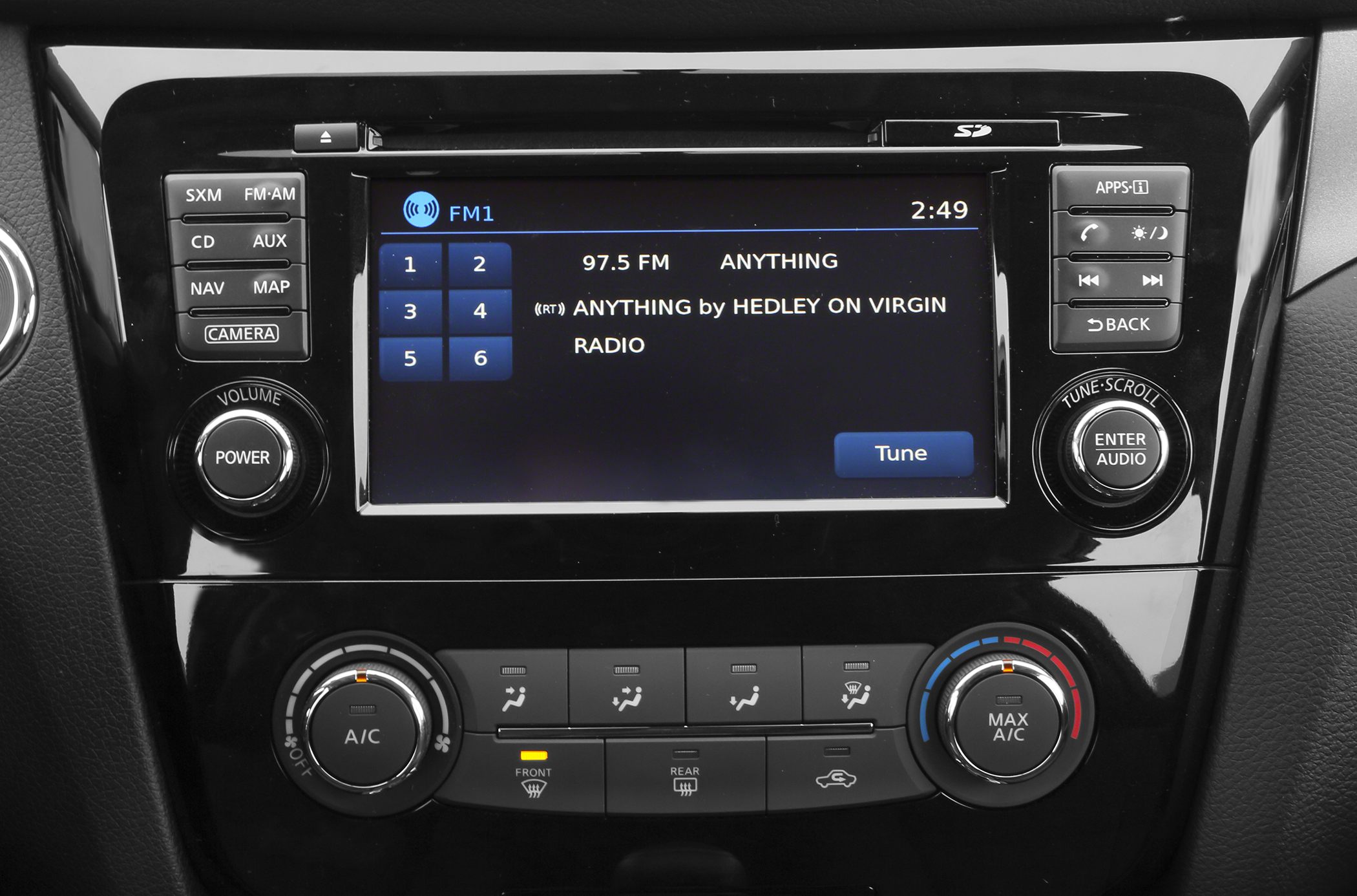 Infotainment screen displaying FM radio and climate control panel with dual A/C knobs