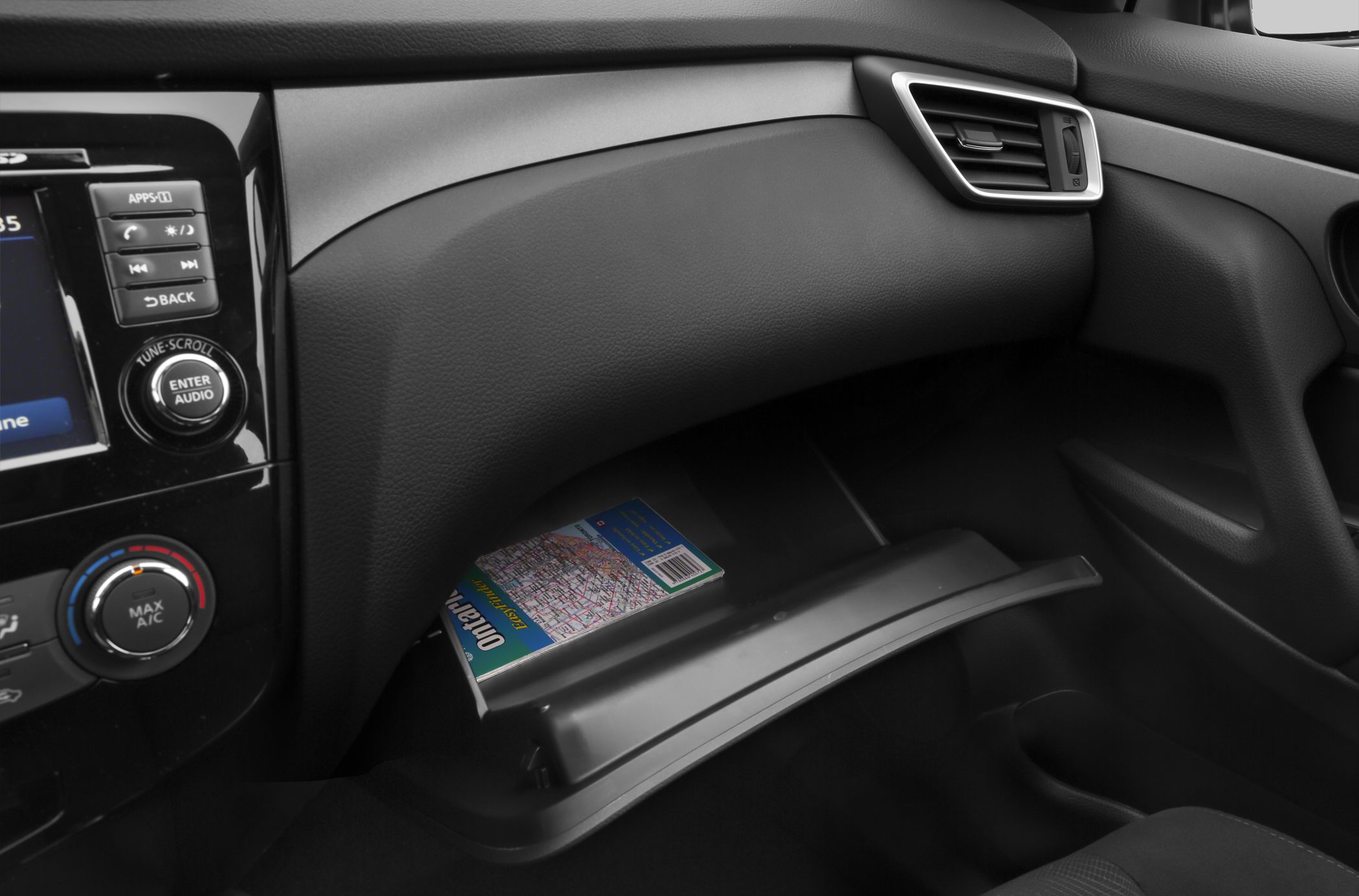 Open glove compartment and dashboard controls with ventilation grill.
