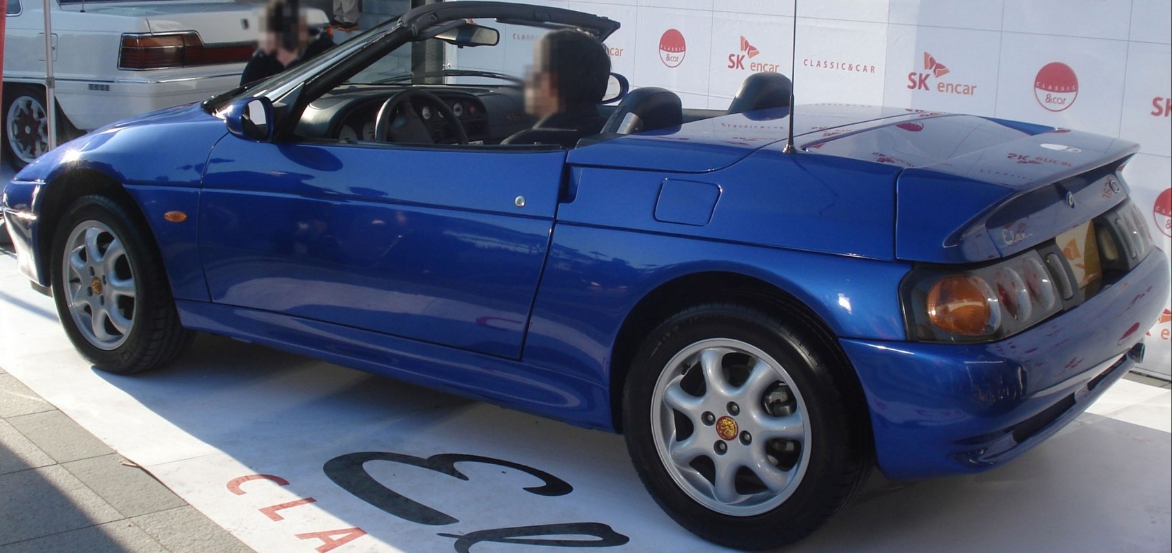 Blue two-door convertible with rear spoiler and alloy wheels