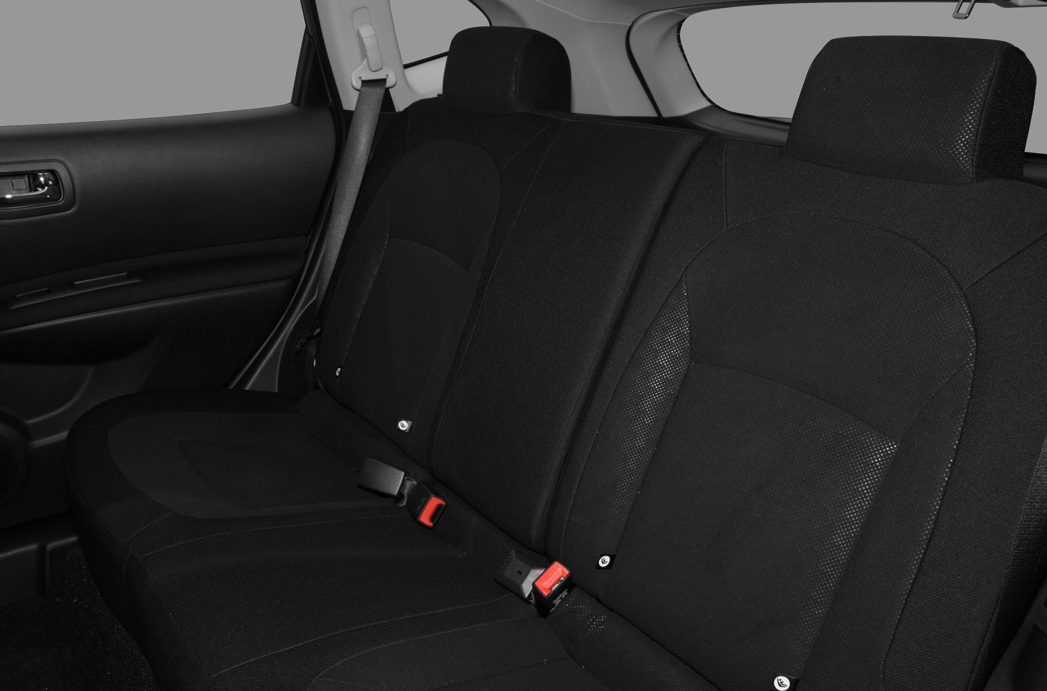 Rear seat interior with black fabric upholstery and seatbelts.