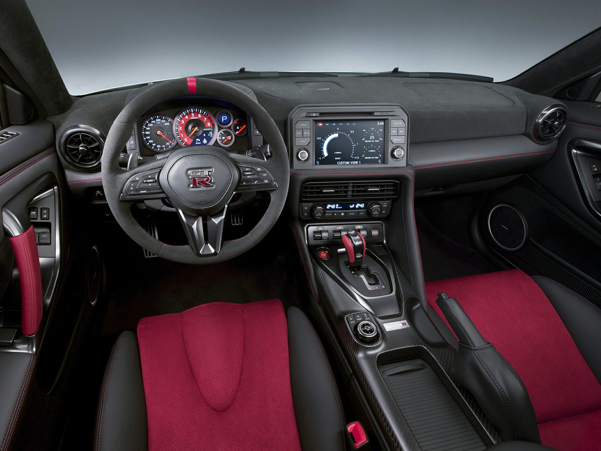 Sporty car interior with leather-wrapped steering wheel and red bucket seats