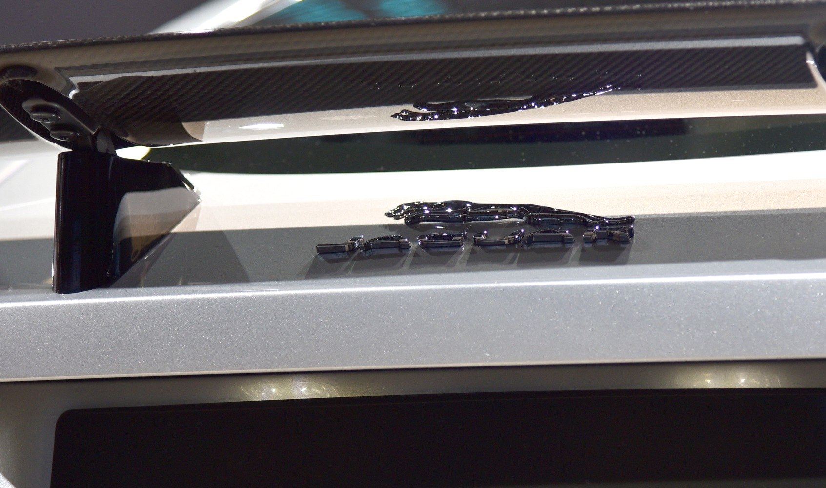 Close-up of rear spoiler and Jaguar badge on car trunk