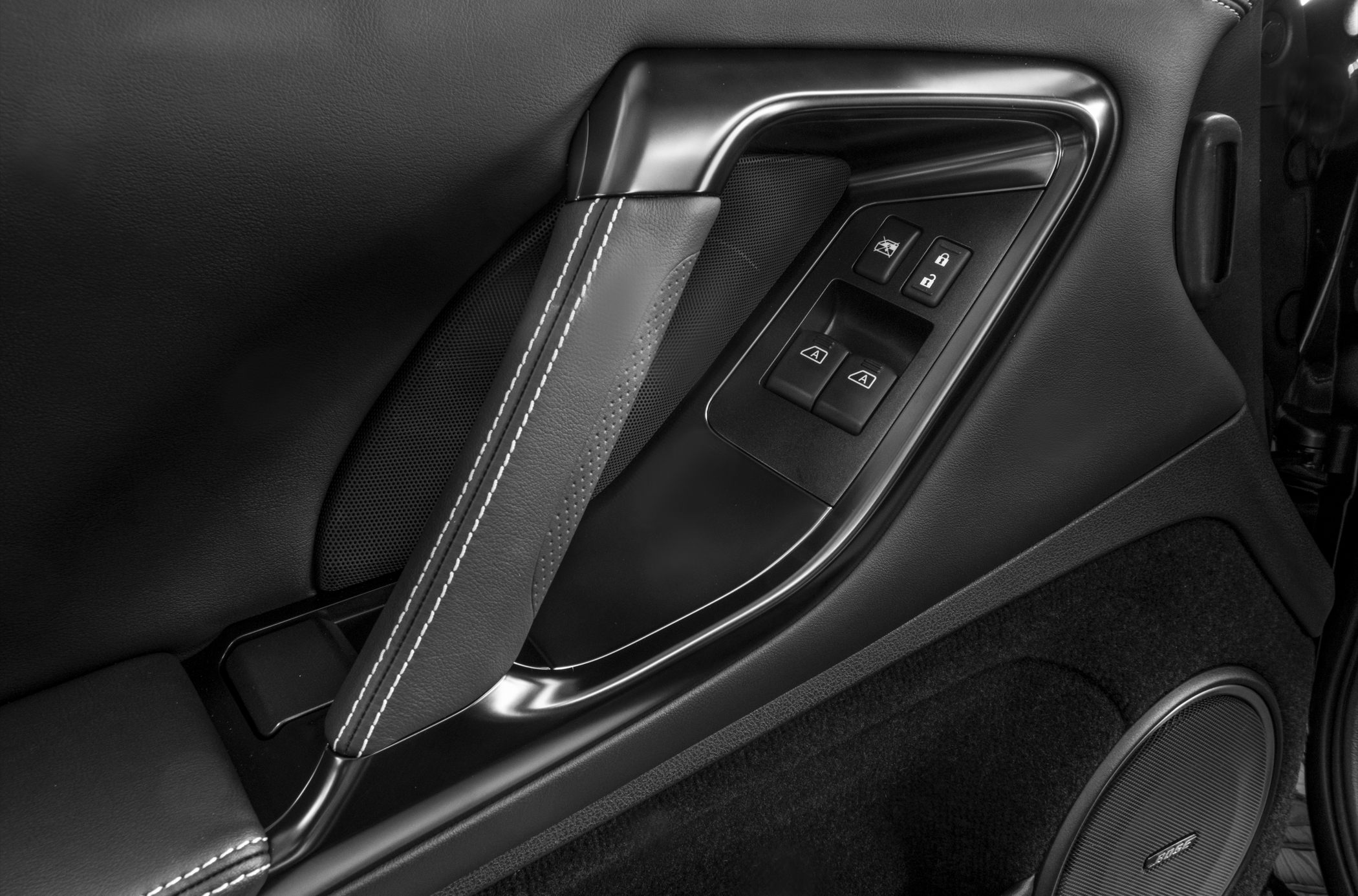 Interior door handle, window control buttons, leather stitching, Bose speaker