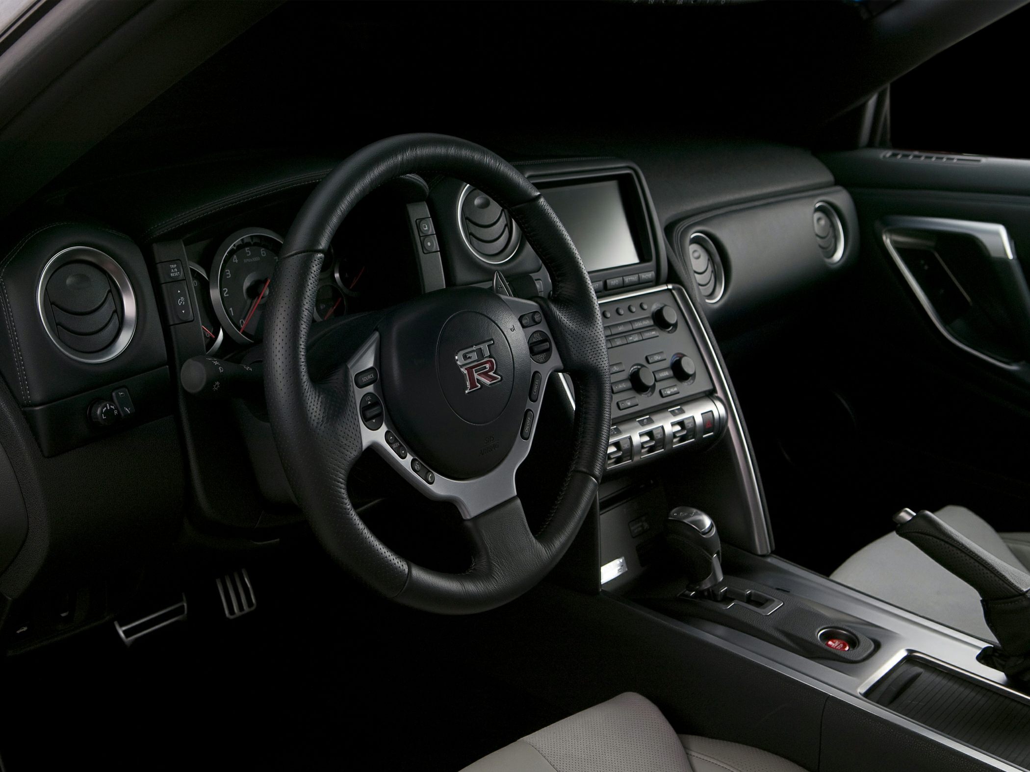 Steering wheel, dashboard, and center console of a sports car interior