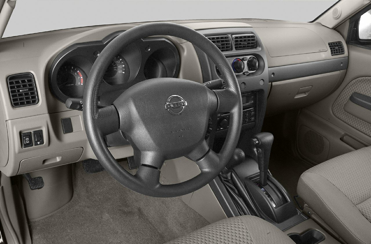 Steering wheel and dashboard interior view with gear shift and beige upholstery.