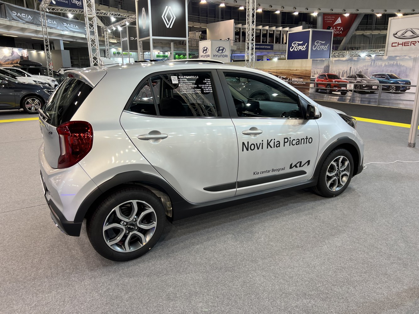 Side profile of compact hatchback with alloy wheels and roof spoiler