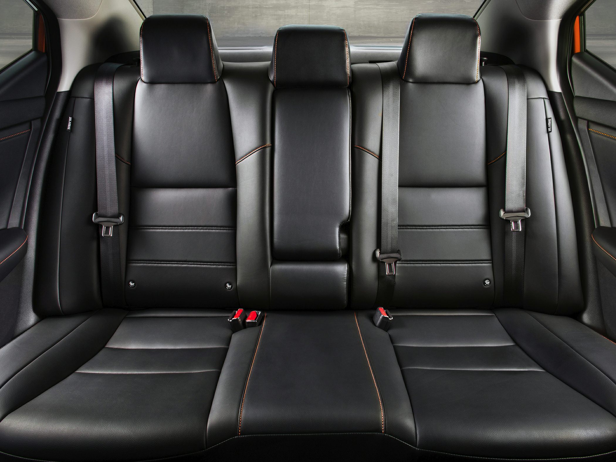 Rear seating with black leather and orange contrast stitching