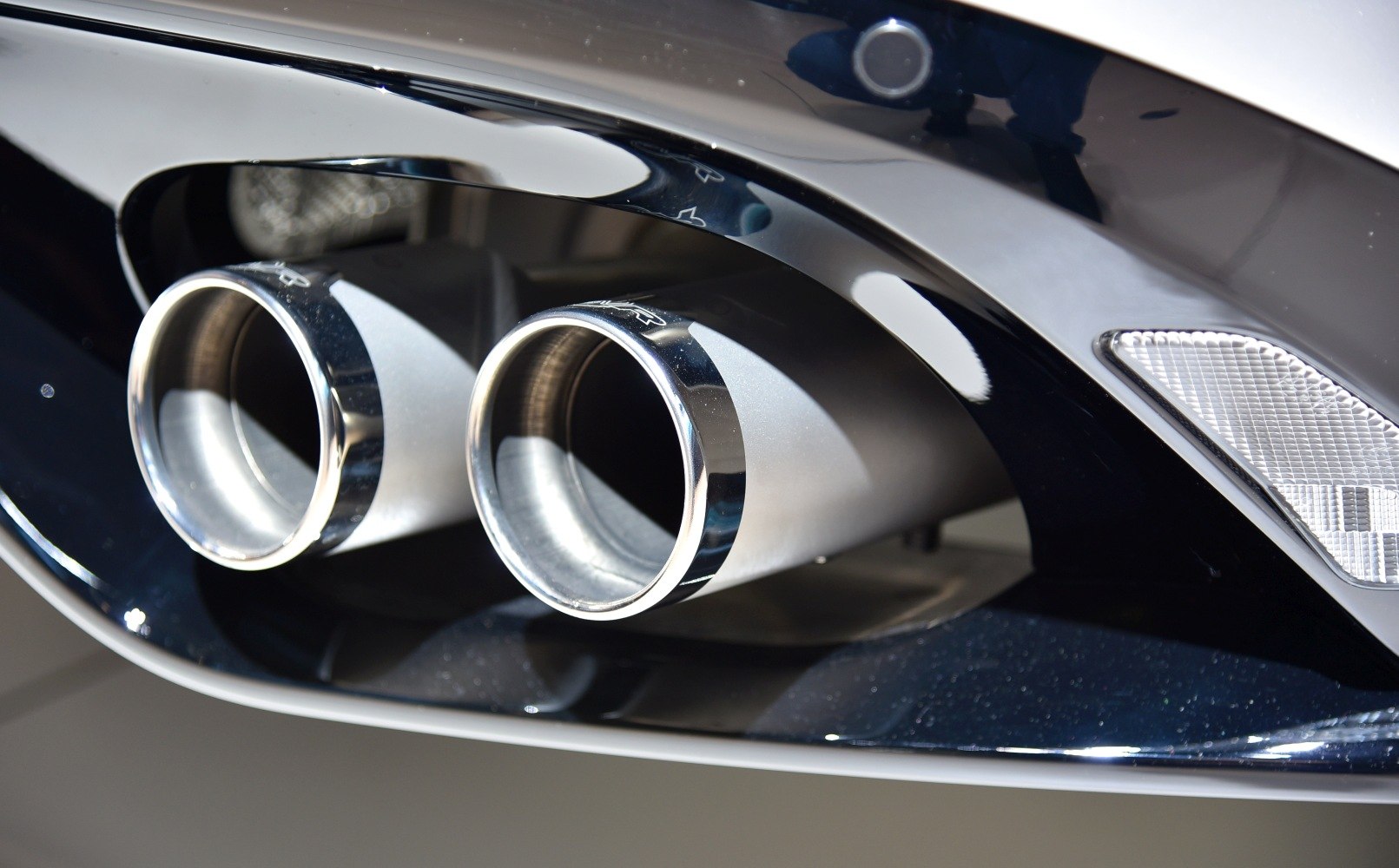 Close-up of dual polished chrome exhaust pipes on rear bumper