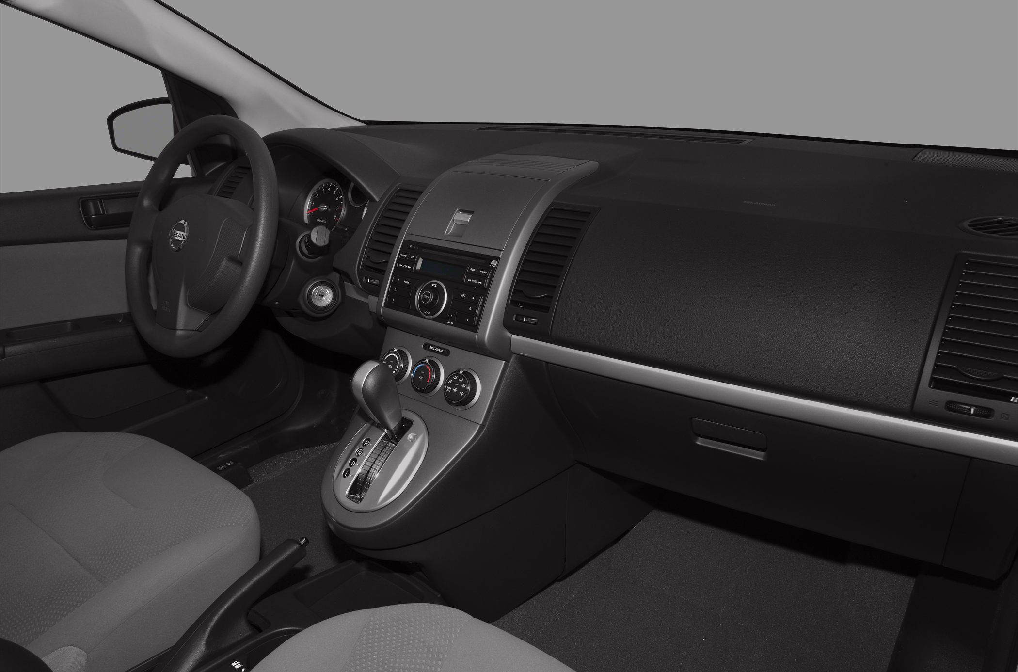 Compact car interior with steering wheel, gear shift, and dashboard controls