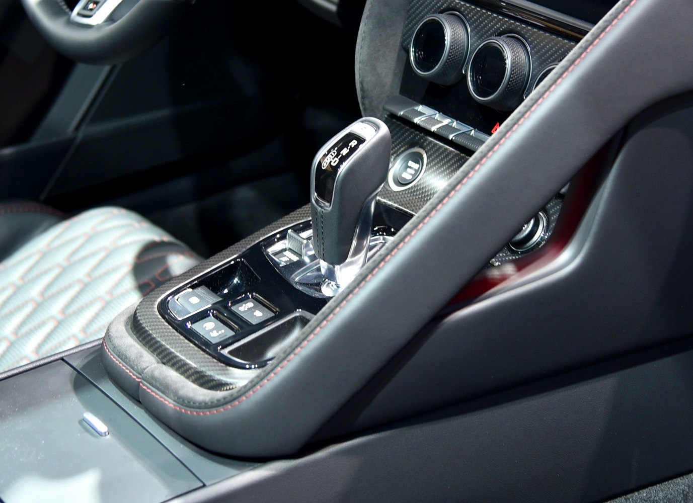 Close-up of gear shift and carbon fiber interior console with leather trim